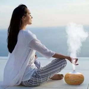 mujer-haciendo-yoga-con-humidificador-y-aromaterapia