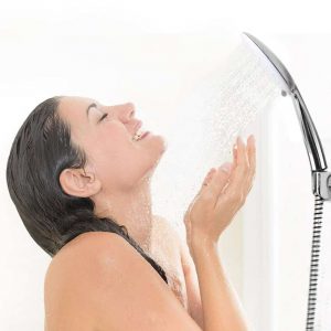 mujer con una ducha de agua fria